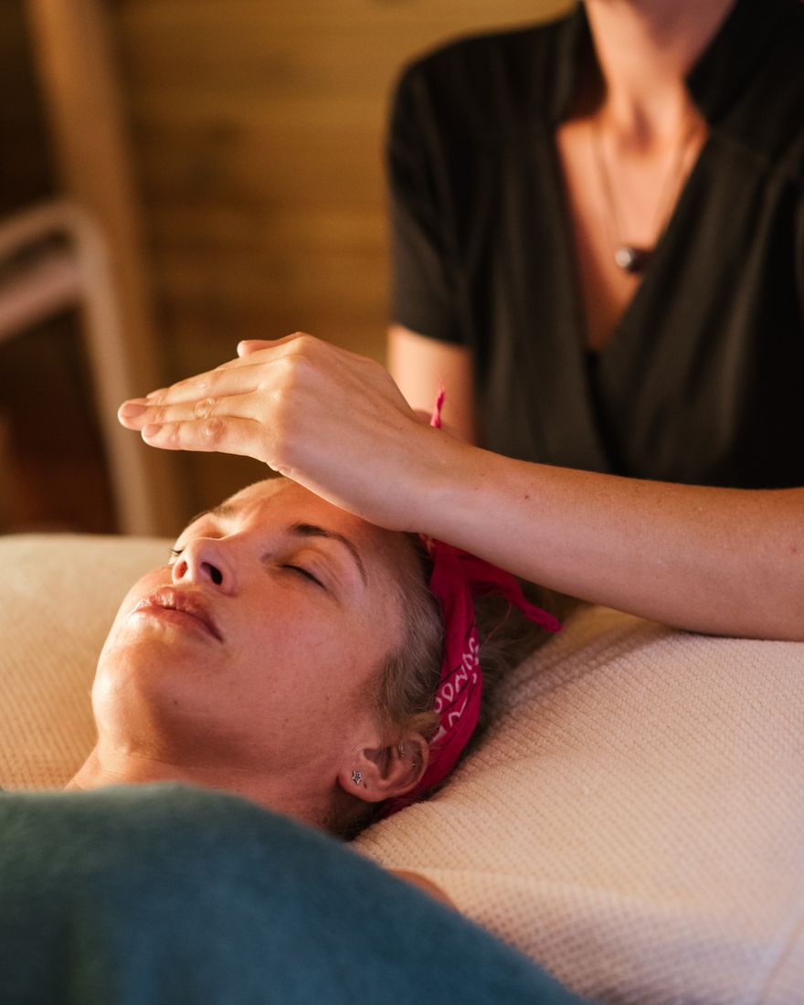Manos quietas sobre el cuerpo durante una sesion de terapia, en luz calida
